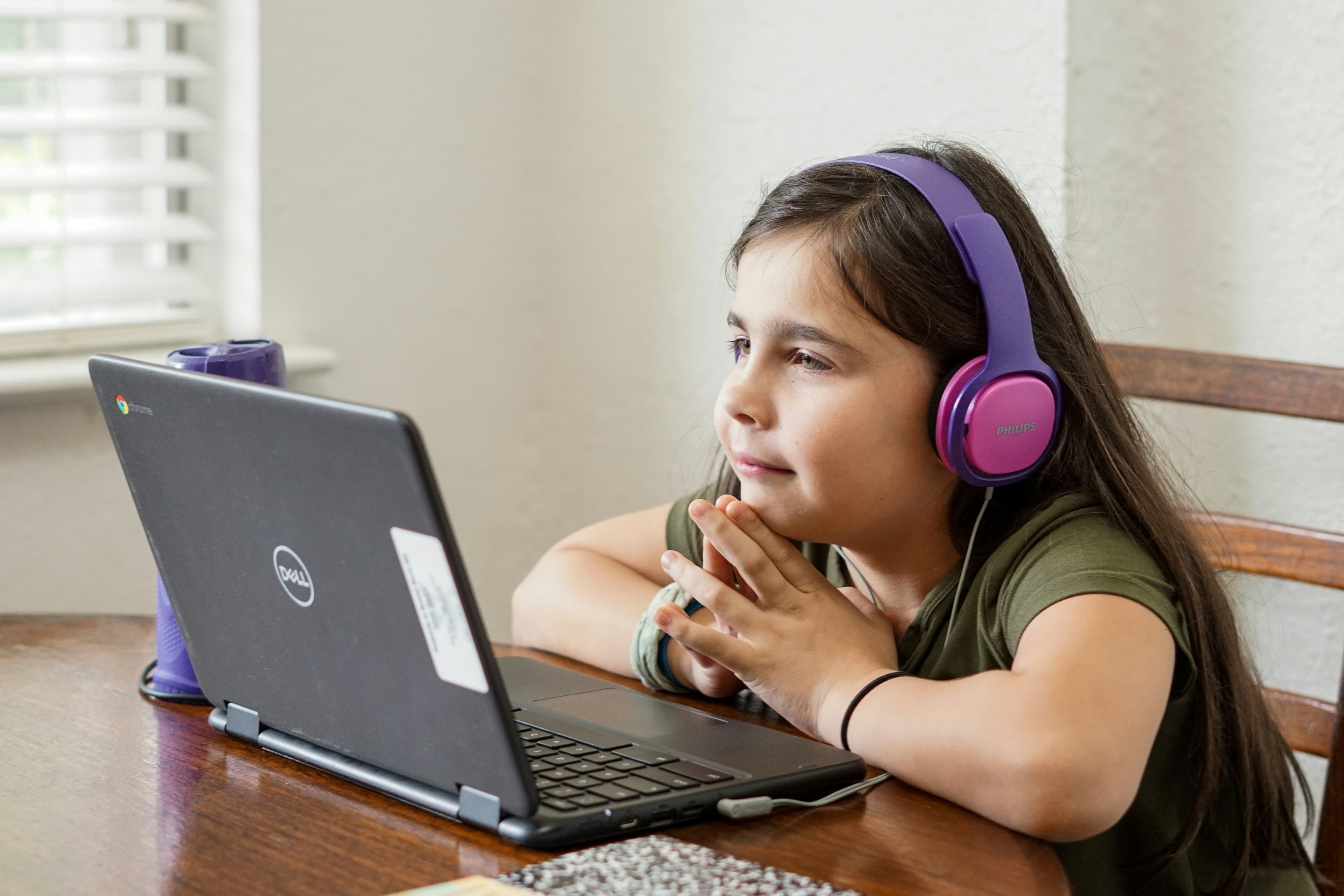 A young girl learning on a laptop